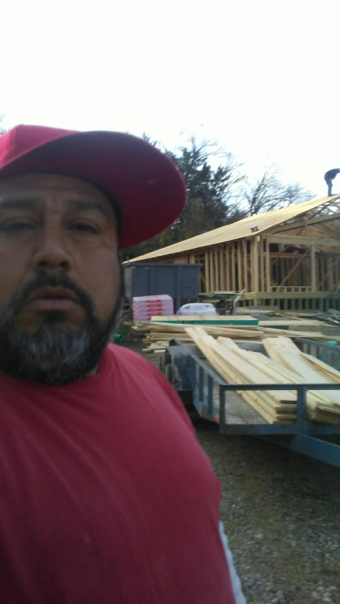 Almazan and Sons owner at a job site with new construction framing in the background